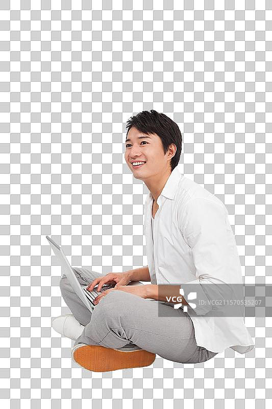 棚拍休闲装年轻男人使用笔记本电脑图片素材