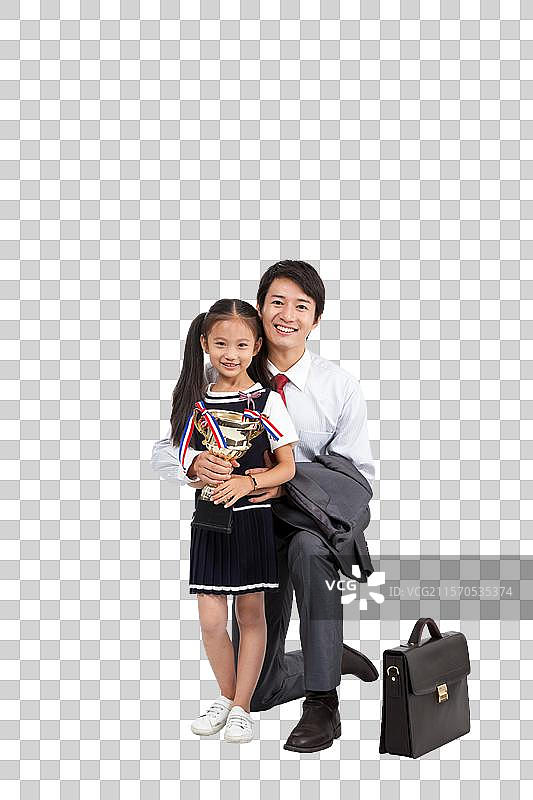 棚拍商务装年轻父亲穿裙子的小女孩抱奖杯图片素材