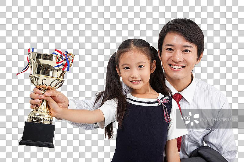 棚拍商务装年轻父亲穿裙子的小女孩拿奖杯图片素材