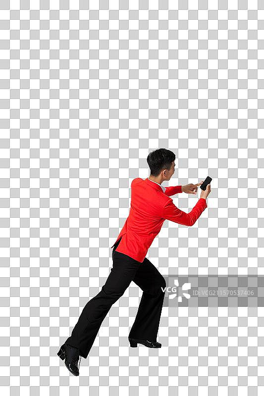 棚拍穿红色西装的年轻男人拿着手机跳舞图片素材