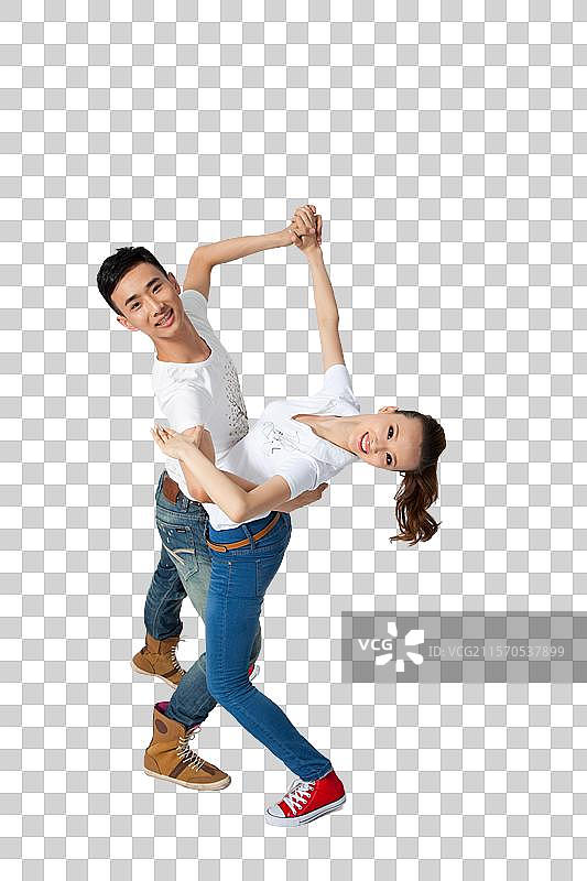 棚拍穿休闲装的年轻情侣跳舞图片素材
