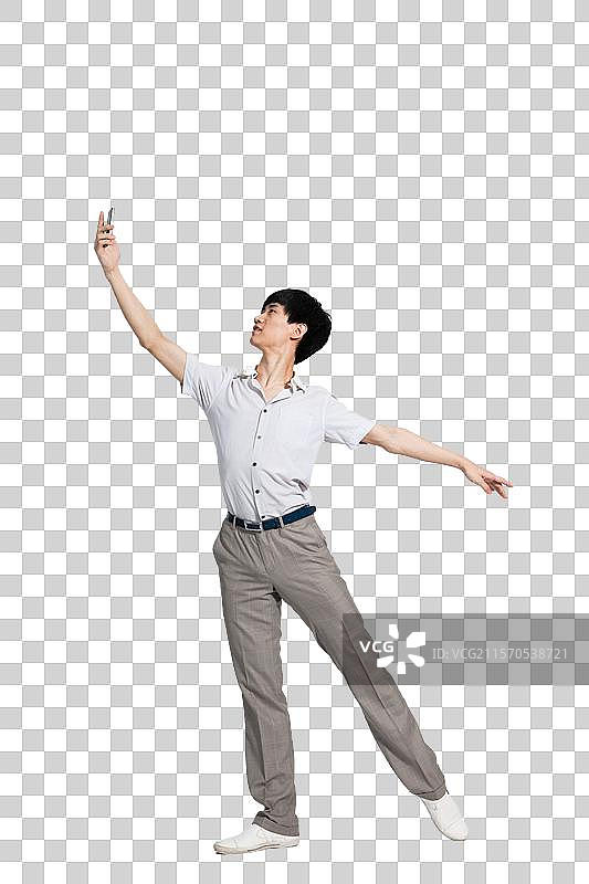 棚拍年轻男人拿着手机跳舞图片素材