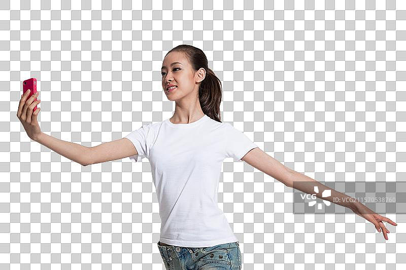 棚拍年轻女人拿着手机跳舞图片素材