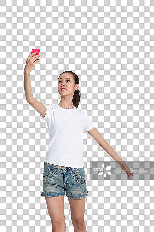 棚拍年轻女人拿着手机跳舞图片素材