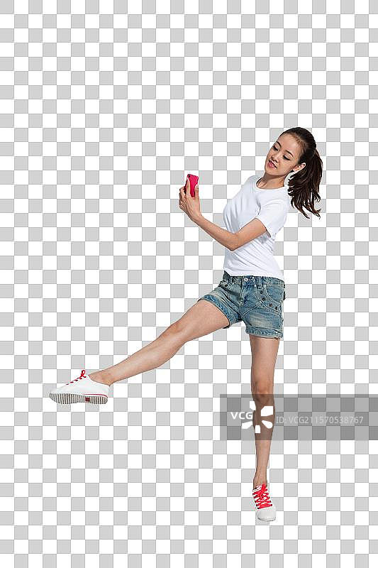 棚拍年轻女人拿着手机跳舞图片素材