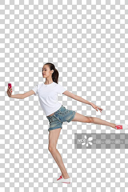 棚拍年轻女人拿着手机跳舞图片素材