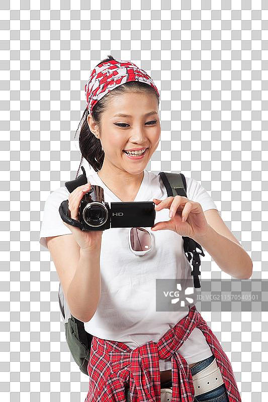 棚拍年轻女人户外旅行拿着DV拍摄图片素材