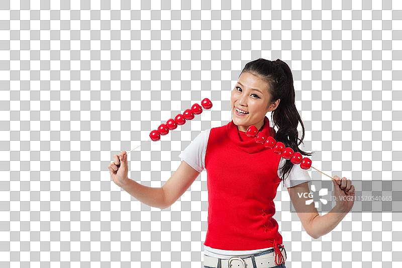 棚拍年轻女人拿着糖葫芦图片素材