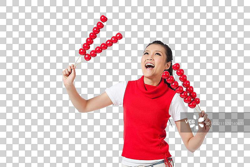 棚拍年轻女人拿着糖葫芦图片素材