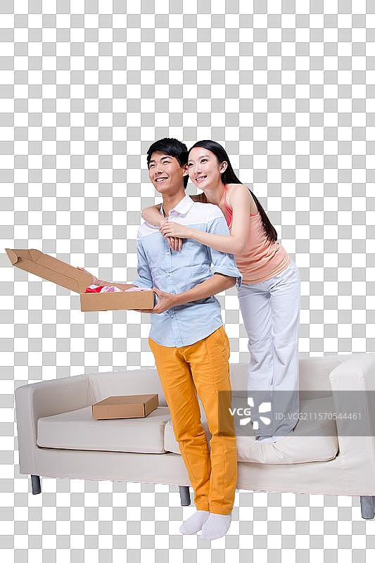 棚拍年轻情侣打开快递盒图片素材