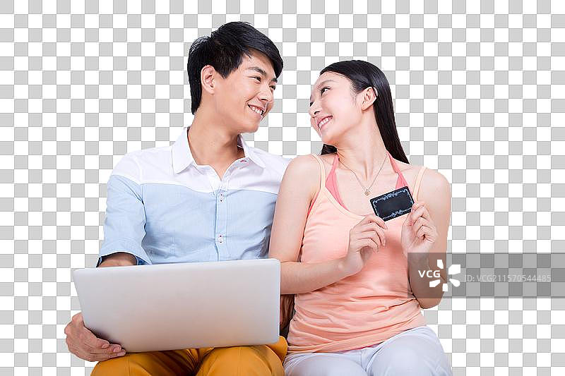 棚拍年轻情侣拿着银行卡上网图片素材