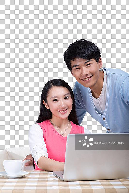 棚拍年轻情侣使用笔记本电脑图片素材