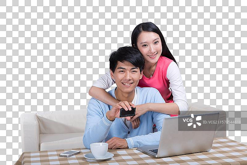 棚拍年轻情侣使用笔记本电脑图片素材