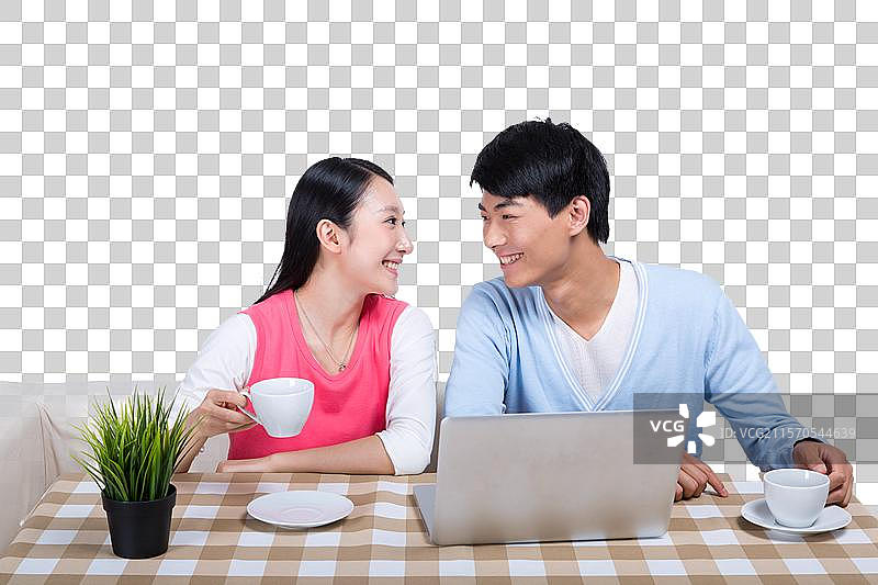 棚拍年轻情侣使用笔记本电脑图片素材