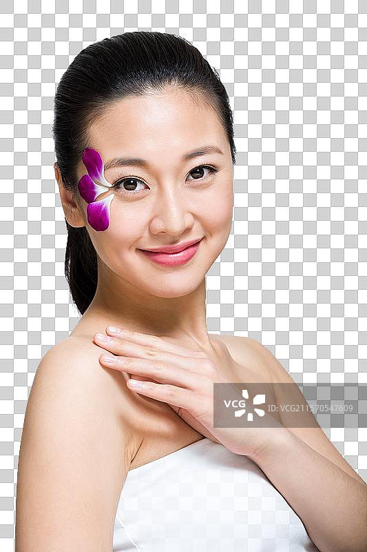 棚拍脸上贴花瓣的年轻女人图片素材