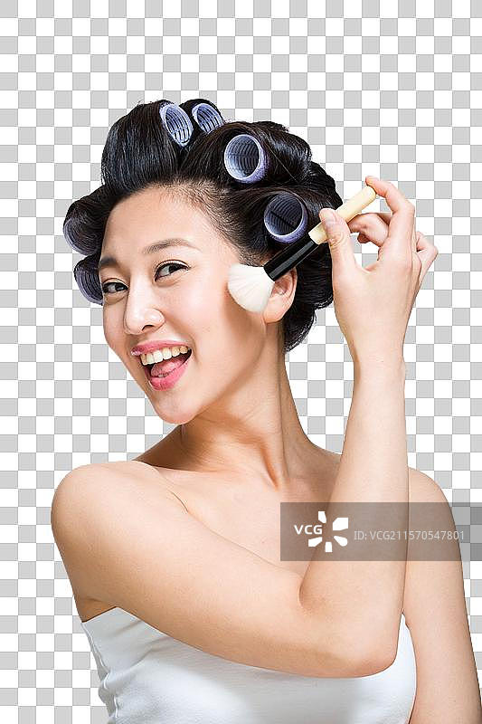 棚拍戴着卷发棒的年轻女人化妆图片素材