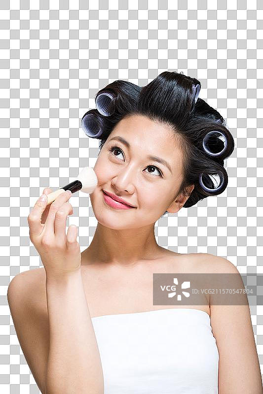 棚拍戴着卷发棒的年轻女人化妆图片素材