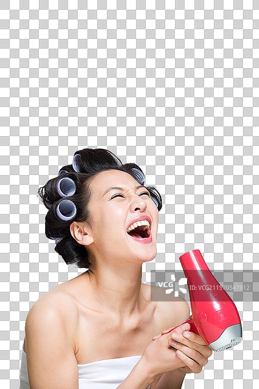棚拍戴着卷发棒的年轻女人吹干头发图片素材