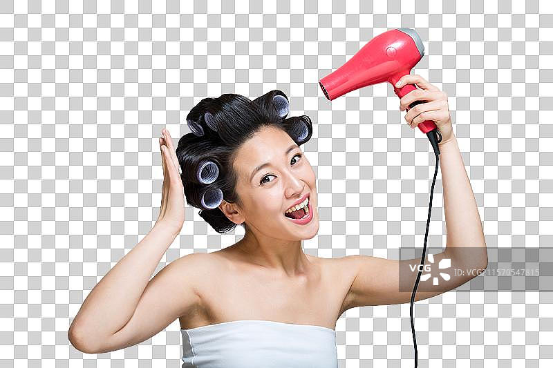 棚拍戴着卷发棒的年轻女人吹干头发图片素材