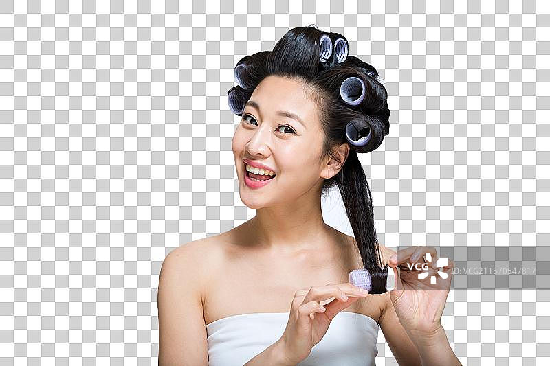棚拍戴卷发棒的年轻女人图片素材