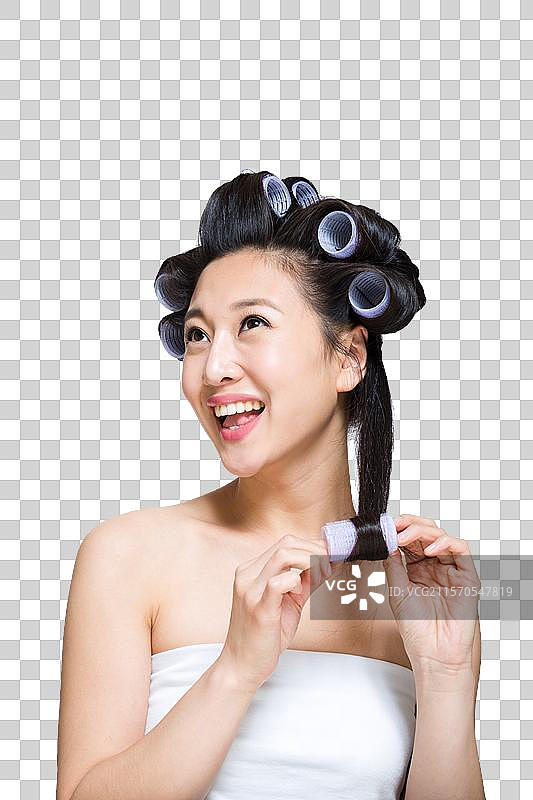 棚拍戴卷发棒的年轻女人图片素材