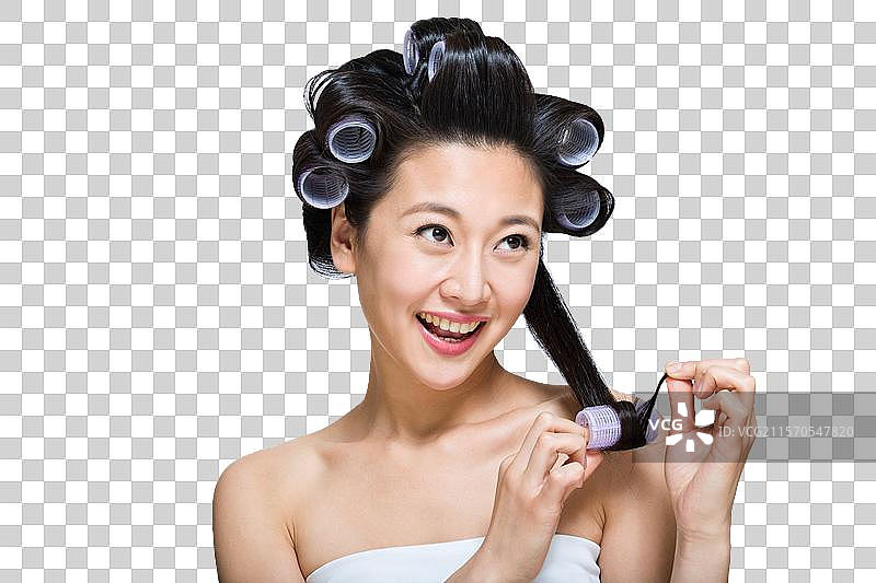 棚拍戴卷发棒的年轻女人图片素材