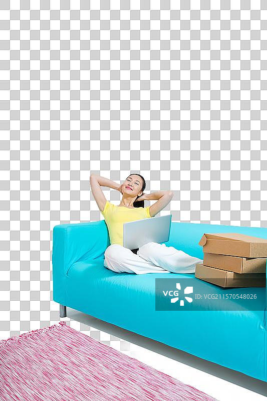 棚拍年轻女人坐在沙发上上网购物图片素材