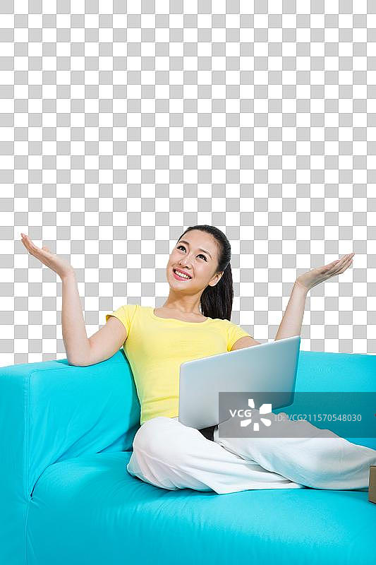 棚拍年轻女人坐在沙发上上网购物图片素材
