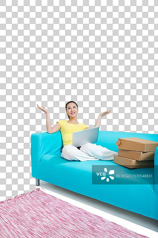 棚拍年轻女人坐在沙发上上网购物图片素材