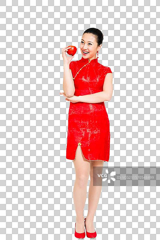 棚拍穿红色旗袍的年轻女人拿着苹果图片素材
