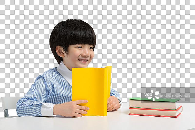 小男孩坐在书桌前看书图片素材
