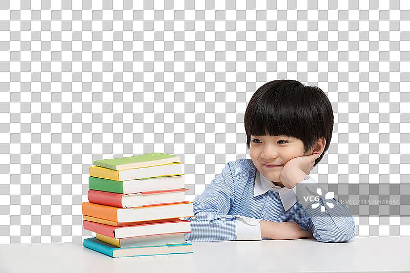 小男孩在书桌前思考图片素材