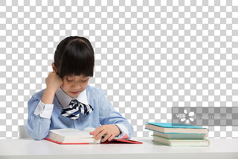 小女孩坐在课桌前看书图片素材