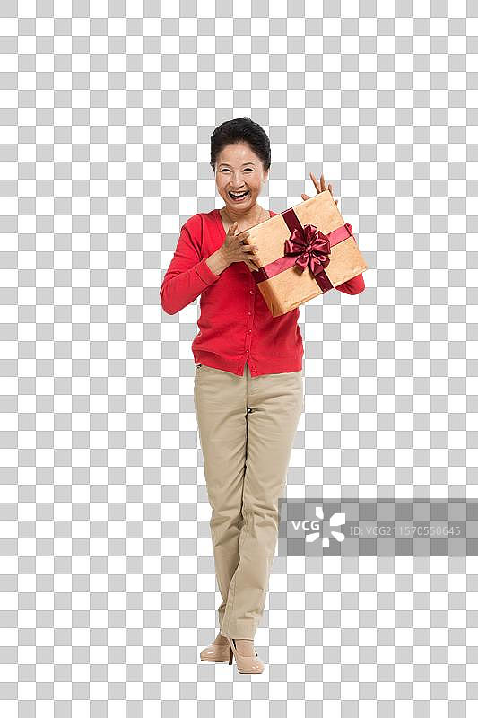 棚拍中老年女性抱着礼物盒图片素材