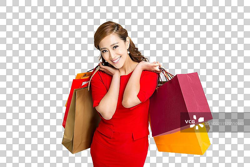 棚拍红裙子的年轻女人提着购物袋图片素材