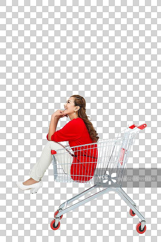 棚拍年轻女人坐在购物车里图片素材