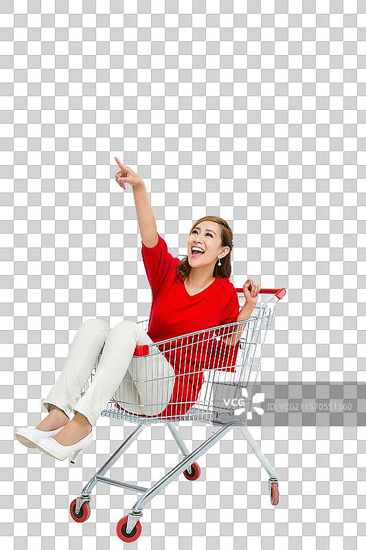 棚拍年轻女人坐在购物车里图片素材