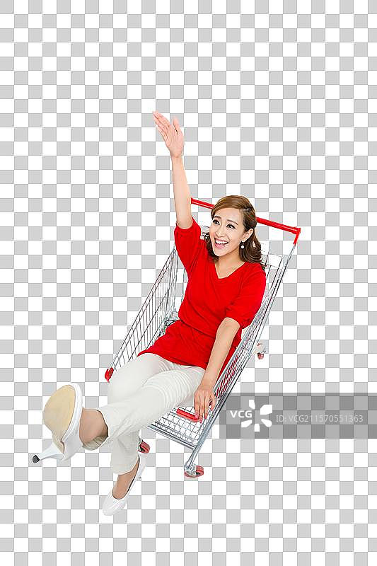 棚拍年轻女人坐在购物车里图片素材