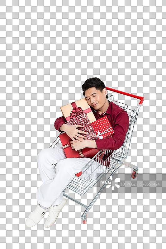 棚拍年轻男人坐在购物车里图片素材