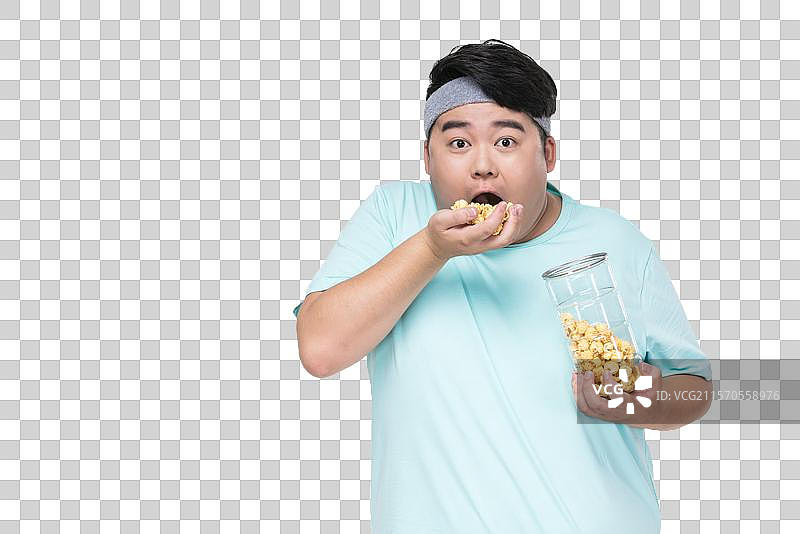 肥胖的年轻男子吃爆米花图片素材