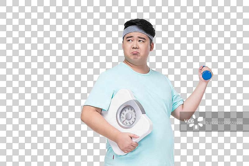 肥胖的年轻男子拿着体重秤健身图片素材