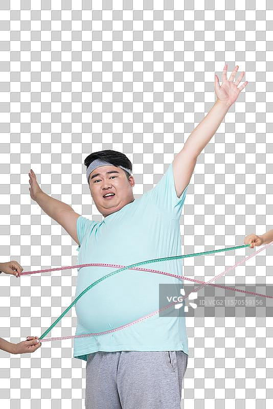 肥胖的年轻男子量腰围图片素材