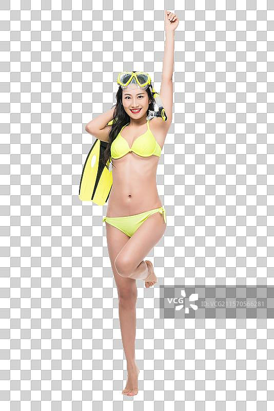 身穿黄色比基尼的年轻女子拿着潜水装备图片素材