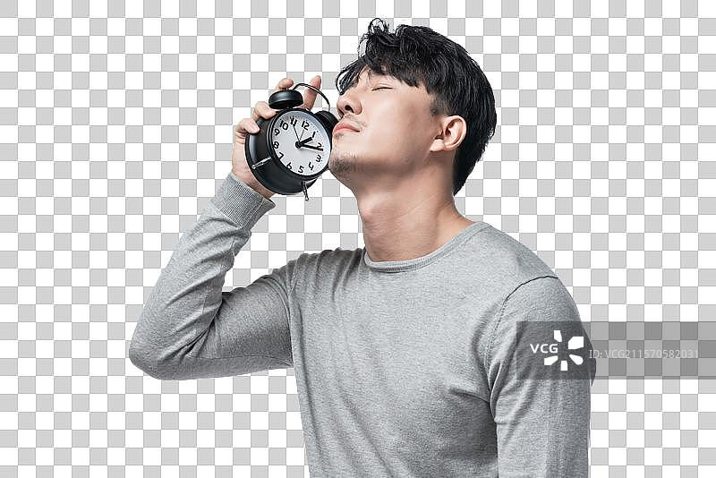 年轻男子拿着闹钟图片素材