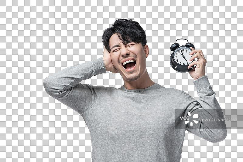 年轻男子拿着闹钟图片素材