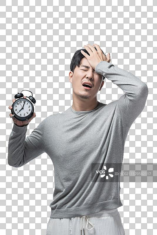 年轻男子拿着闹钟图片素材