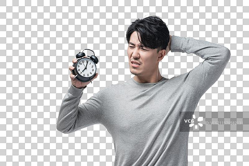 年轻男子拿着闹钟图片素材