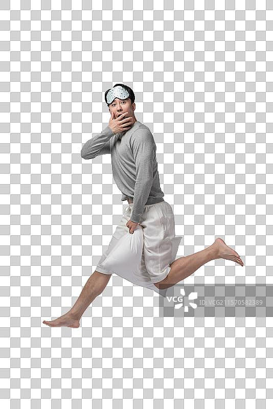 年轻男子拿着枕头图片素材