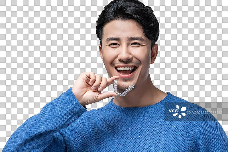 年轻男子拿着透明牙套图片素材