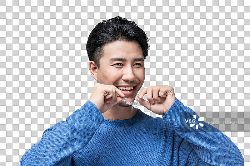 年轻男子拿着透明牙套图片素材